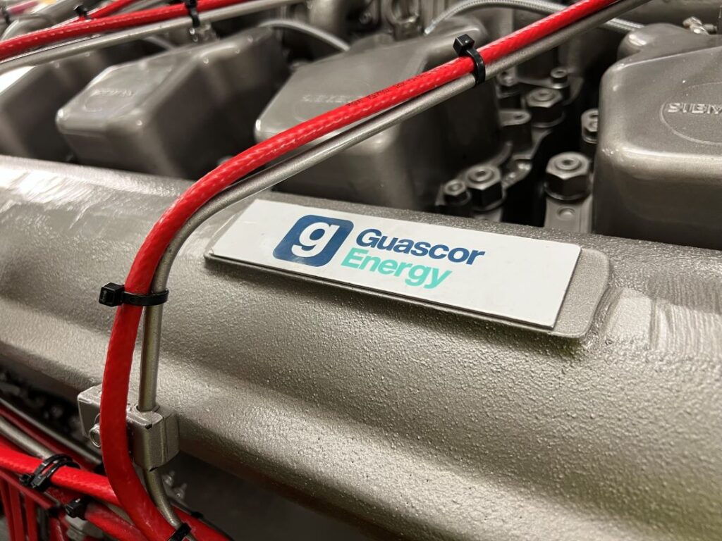 Close-up of a Fleetsolve Guascor CHP gas engine with a visible label, showcasing its components and design.